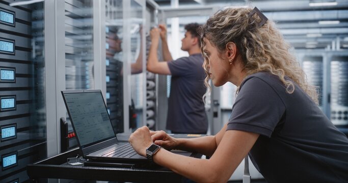 Female Cybersecurity Engineer Analyzes Cyber Attack Warning Through Terminal Interface, Checking System Health and Applying Emergency Console Procedures to Protect Critical Data Center Infrastructure.