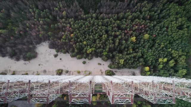 Aerial view of the massive Duga 1 Receiver radar array rising above the surrounding forest and sandy terrain in Chernobyl, Kyiv Oblast, Ukraine.