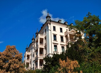Wiesbaden, Hesse, Germany – Elegant historic residential building with balconies and decorative turrets surrounded by mature trees. © Edgar