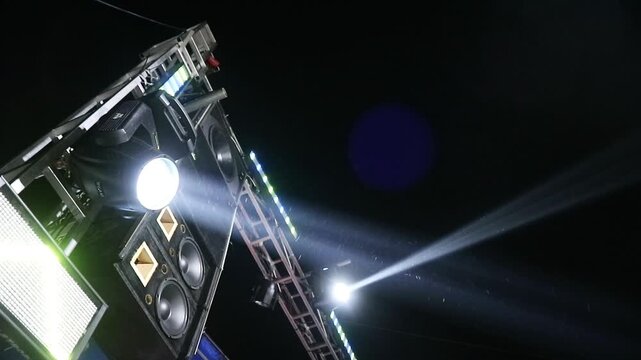 Professional stage lighting equipment with bright beams shining in the dark night.