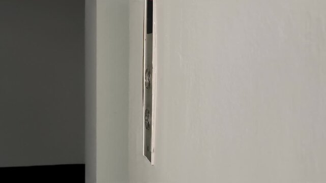 hand closeup of southeast asian senior man with tan skin pressing elevator button in an old building lobby, elderly finger pushing up or upstair button