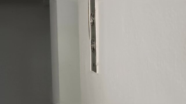 hand closeup of southeast asian middle aged  woman with light complexion pressing elevator button in an old building lobby, chubby hand and finger pushing down or downstair button