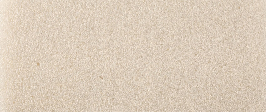 Close-up of polyurethane foam texture. Beige sponge porous surface background