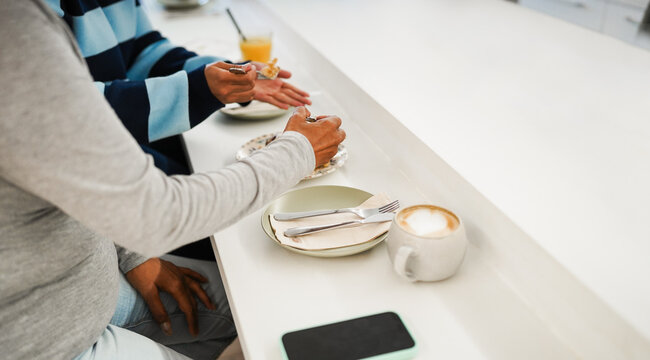 People doing breakfast during morning time while eating pastry and drinking coffee and orange juice - Food and lifestyle concept - Main focus on right hand - UGC content