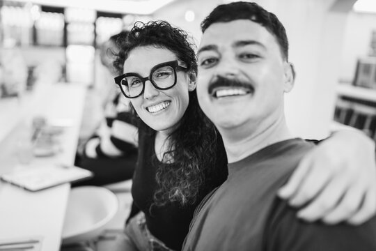 Happy couple eating inside brunch bar during morning time - Healthy food and people lifestyle concept - Main focus on woman face - Black and white UGC content