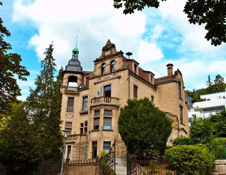 Wiesbaden, Hesse, Germany &ndash; Elegant historic stone villa with ornate facade, tower, balconies and landscaped greenery.