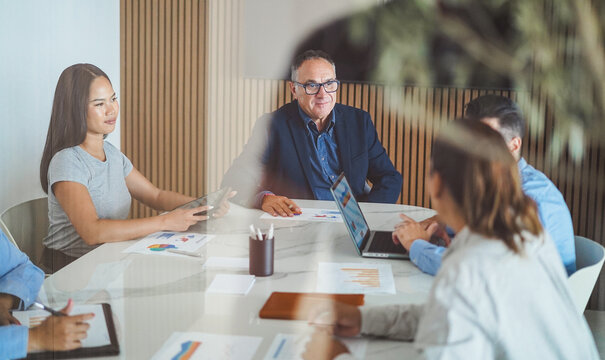 Multiracial colleagues working inside business office with glass walls - Entrepreneurs people sharing ideas at teamwork meeting - Brainstorming concept - Main focus on center man face