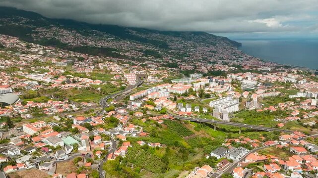 Aerial drone view of Funchal town, Madeira Island, Portugal. Slide trucking shot