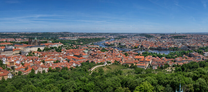 A panoramic aerial view shows the cityscape of Prague in summer