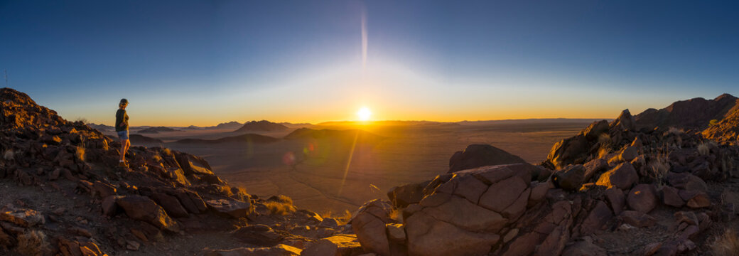 Africa, Namibia, Hardap, Hammerstein, Kulala Wilderness Reserve, Tsaris Mountains, woman standig at namib desert at sunset