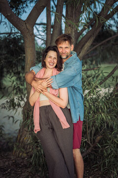 A happy couple embraces outdoors during a summer beach vacation
