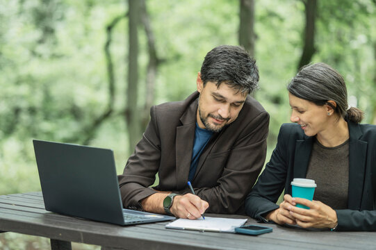 Businessman and businesswoman discuss a decision outdoors