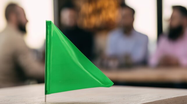 Green flag placed on a table in a busy cafe during a casual meeting