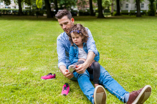 Father putting daughter's shoes on