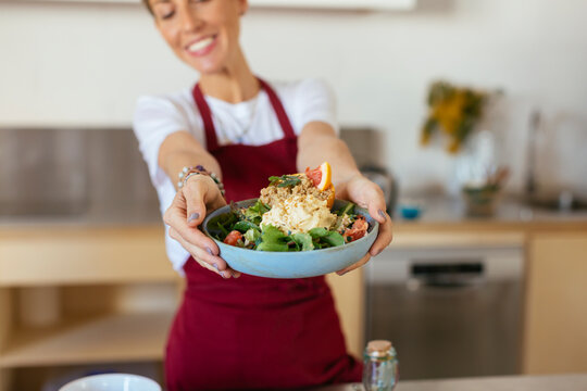 Woman serving meal in kitchen