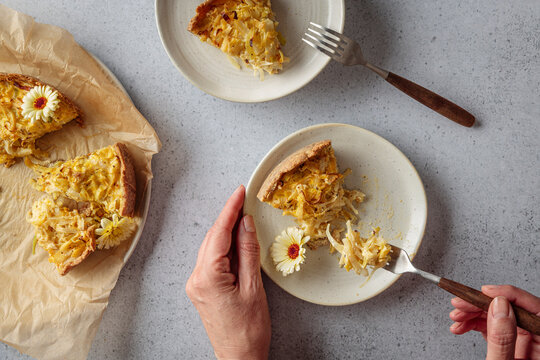 Mature woman eating healthy white cabbage quiche indoors