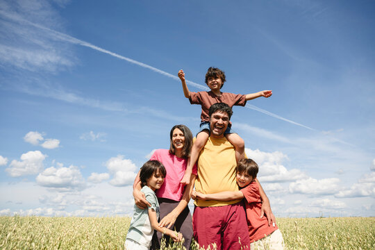 Happy family enjoys a summer day in the crop field