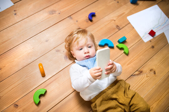 Lttle boy at home playing with smartphone