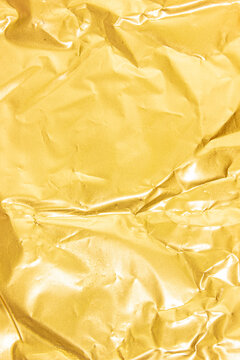 Gold foil paper texture background with shiny metallic surface, subtle wrinkles, reflective highlights, and elegant details, creating a luxurious backdrop for invitations, packaging, branding, crafts,