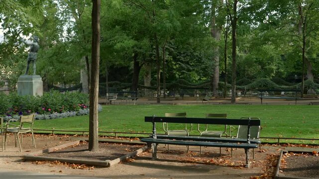 Green chairs and statue among flower beds in Luxembourg Gardens