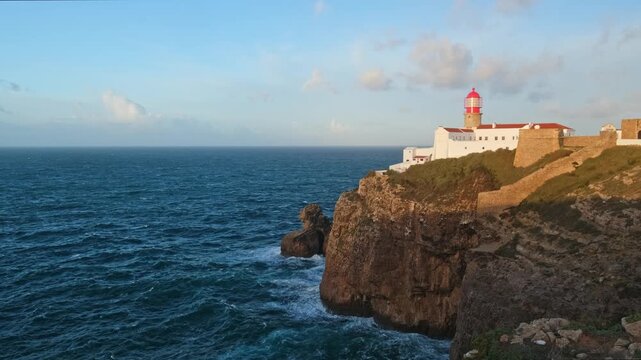 Cabo de Sao Vicente Lighthouse above Atlantic cliffs at sunrise in Sagres, Algarve, Portugal