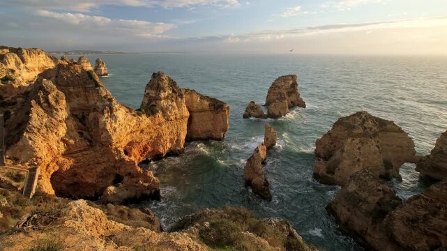 View of Ponta da Piedade in Lagos, Algarve, Portugal, with morning light over Atlantic water and rugged limestone formations
