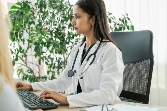 Female doctor typing on keyboard during consultation at the hospital