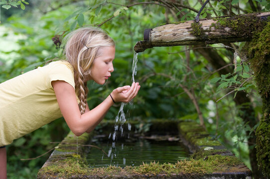 Austria, Mondsee, Girl (12-13 Years) drinking water from water spout