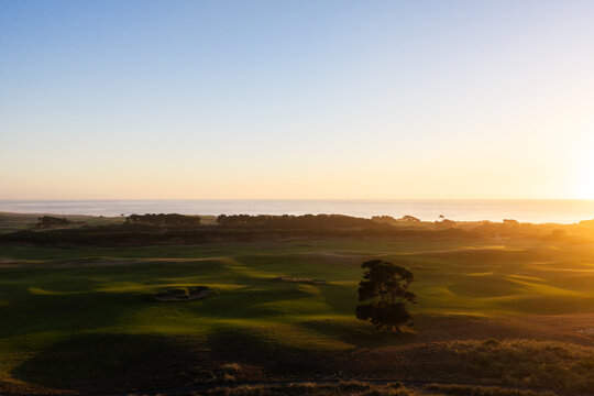 Aerial view of a scenic golf course right on the rugged ocean coastline at dusk in Bandon, Oregon.