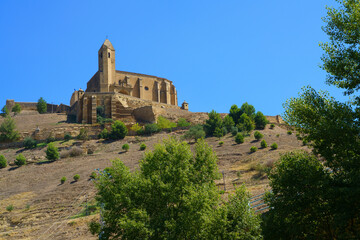 Fototapeta premium picturesque view of a traditional stone church overlooking a dry, rolling landscape near Rioja, Spain, showcasing rustic countryside charm.