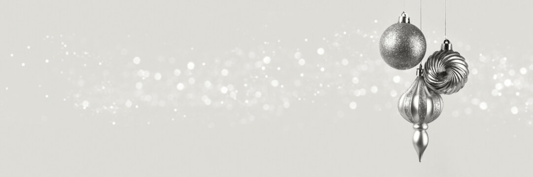 Christmas banner with three silver balls decorations on cloud white dancer background with bokeh lights with copy space. Wide panoramic header. Demonstrating color, trend 2026 year