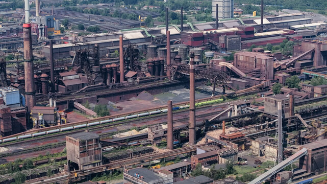 Aerial view of the large steelworks and heavy industrial complex featuring tall chimneys, blast furnaces, and extensive railway infrastructure in Ostrava, Moravian-Silesian Reg, Czechia.