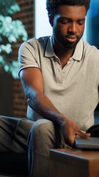 African American business woman coming in room open laptop starting working at evening home office ethnic male start work with computer serious guy worker businesswoman come in apartment using device