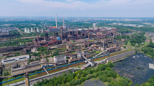 Aerial view of the large steelworks and heavy industrial complex featuring blast furnaces, factory buildings, railway tracks, and surrounding greenery in Ostrava, Moravian-Silesian Reg, Czechia.