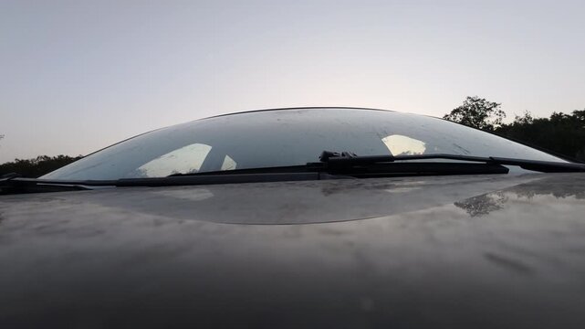 Low Angle Close Up of Car Hood and Windshield at Sunset