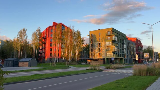 Modern residential building at sunrise in neighborhood. Walkway in contemporary apartment condo complex. Modern building block on sunset. New residential multifamily home in eco neighborhood. 