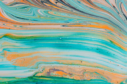 Horizontal waves turquoise orange and beige liquid paint forming soft pastel abstract art.
