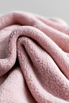 Soft pink fleece fabric displaying smooth folds and plush texture.