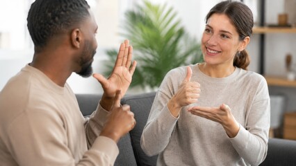 Fototapeta na wymiar Diverse Couple Communicating with Sign Language During Friendly Conversation at Home