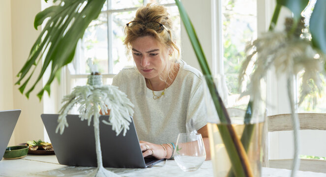 young woman working on laptop in light filled room