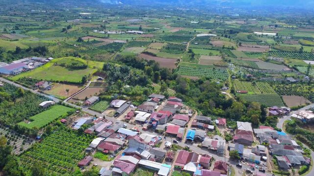 Aerial view of the village of Naman Teran near Mount Sinabung with lush agricultural fields and rural houses in Naman Teran, North Sumatra, Indonesia.