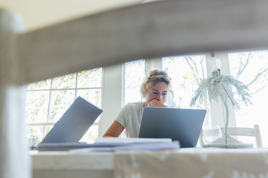 young woman working on laptop in light filled room