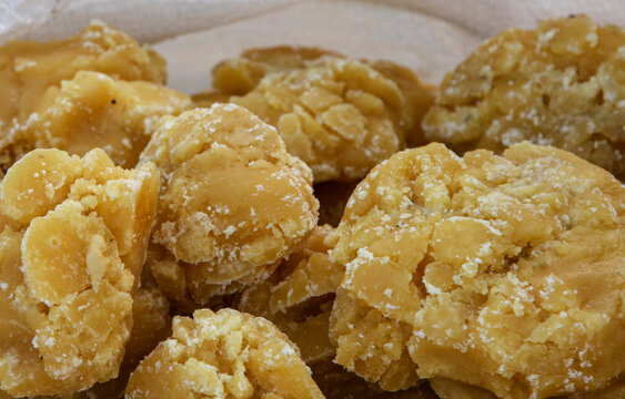 View of jaggery pieces, a traditional non-centrifugal cane sugar with a textured surface and golden brown color in Multan, Punjab, Pakistan.