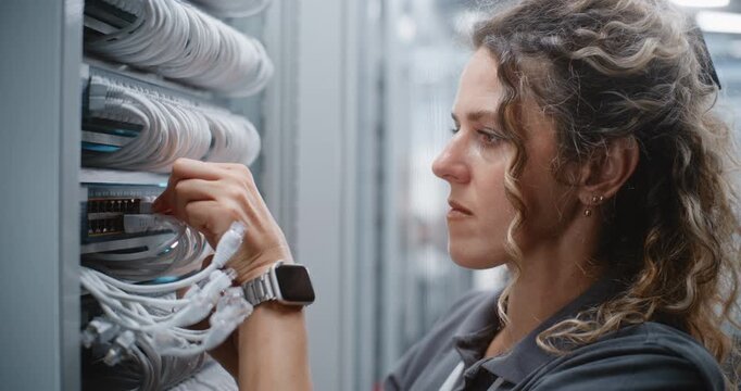 Female Network Specialist Reconnects Patch Cords Between Patch Panel and Switch, Maintaining Organized Rack Wiring and Stable Physical Network Connections For Structured Cabling in Data Center.