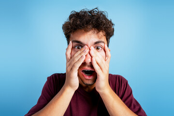 Young man reacting with surprise and fear expression