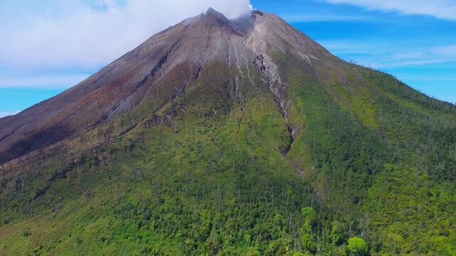 Aerial view of Mount Sinabung with its volcanic crater and lush green slopes in Naman Teran, North Sumatra, Indonesia.