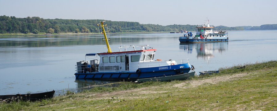Galati, Romania - August 20, 2023: Technical river boat Donaris 2 belonging to the Lower Danube River Administration moored by the calm shore on a sunny day.