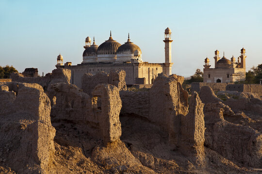 View of the historic Derawar Fort and the adjacent mosque with its domes and minarets rising above the ancient mud-brick ruins in Derawar, Punjab, Pakistan.