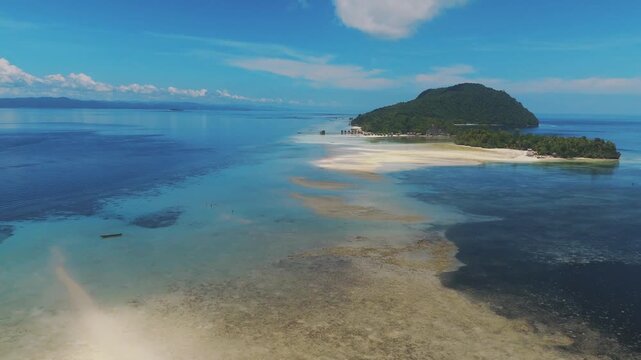 Aerial view of the tropical landscape of Kri Island with a sandbar extending into the turquoise waters of Raja Ampat Regency, Kri Island, Southwest Papua, Indonesia.