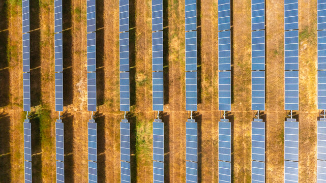 Aerial view of rows of solar panels arranged in long parallel lines across a dry grassy field in Klamath Falls, Oregon, United States.